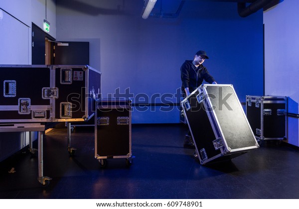 Roadie tipping a\
flightcase over on it\'s\
side