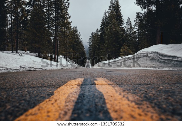 roadless less\
travelled in a national park. road of inspiration and motivation.\
low angle of the pavement with the two yellow divider lines.\
landscape and portrait\
mode\
