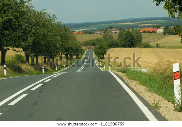 Roads\
running down the hills along the fields and trees.A path leading\
down to the village, photograph in the\
summer.