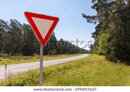 Roadside intersection preceded by a give way sign.