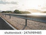 Roadside metal rail barrier structure which is installed on side of the road for protected the car accident. Transportation safety equipment object, selective focus.