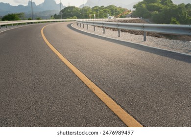 Roadside metal rail barrier structure which is installed on side of the road for protected the car accident. Transportation safety equipment object, selective focus.