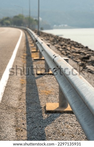Roadside metal rail barrier structure which is installed on side of the road for protected the car accident. Transportation safety equipment object, selective focus.	
 Foto stock © 