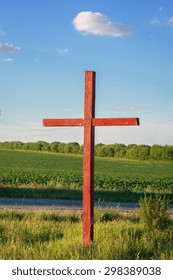 Roadside Painted Wooden Cross On A Background Of Field