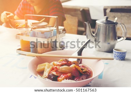 Roadside restaurant of Asia with Thai noodles and background of boy eating his noodle on table.1