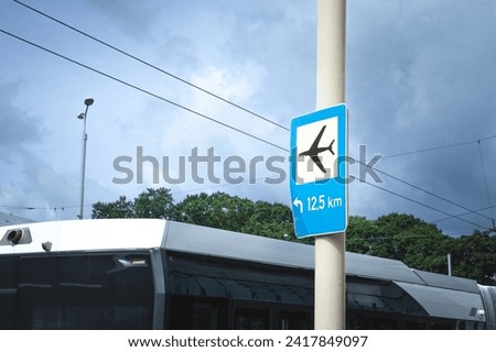 Roadsign indicating the direction to the Airport of Riga with an airport shuttle bus ready for departure. RIX, or Riga Airport is the main airport of Latvia.