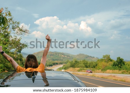 roadtrip concept from solo woman traveler stand from her car with relax and happiness feeling
