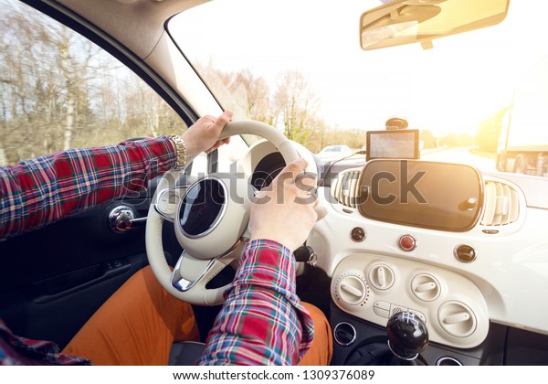 roadtrip - man\'s hands on the wheel and\
autobahn in the\
background\
