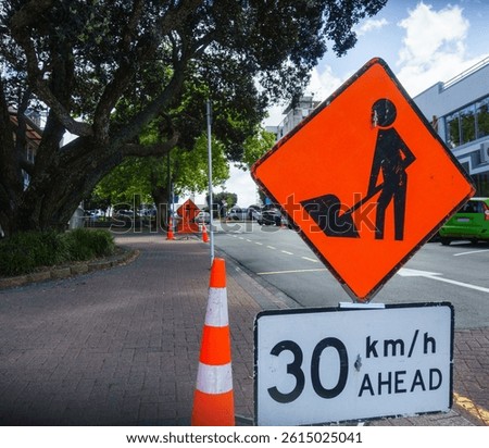 Roadwork Ahead and Please Stop on Request road signs by the road. Roadworks in Auckland.