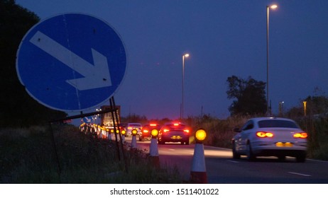 Roadworks Cones Flashing On UK Motorway At Night With Traffic Passing