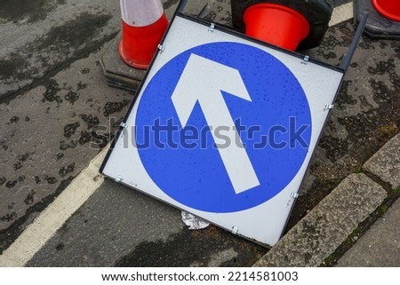 roadworks diversion sign and traffic cones on side of road. Traffic direction sign and bollards. 