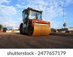 Roadworks, Road construction. Paving roller on roadworks at construction site, paving works. Asphalt paver Road roller on ground Screeding, road concreting. Paving works. Compact soil, gravel, paving 