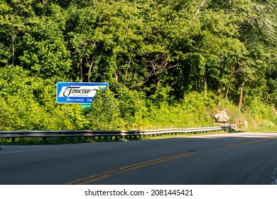 Roan Mountain, Tennessee welcomes you sign on highway from North Carolina on us-19e 19e road in summer with nobody driving point of view