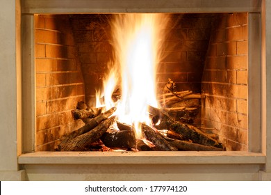 Roaring Fire With Bright Orange Flames Blazing In A Brick Hearth For Indoor Heating, Close Up View