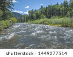 The Roaring Fork River winds through Snowmass Canyon near Snowmass, Colorado and Aspen, Colorado on a sunny spring afternoon.  