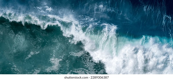 A roaring wave crashes into the deep waters, creating a mesmerizing display of power and beauty, with its frothy white foam contrasting against the deep blue ocean, captured from a high vantage point. - Powered by Shutterstock