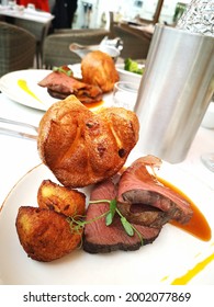 Roast Beef Dinner And Yorkshire Pudding On A Set Tabletop In A Vertical Format With A Water Bottle Chiller - UK