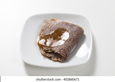 Roast Beef With Gravy On A White Plate