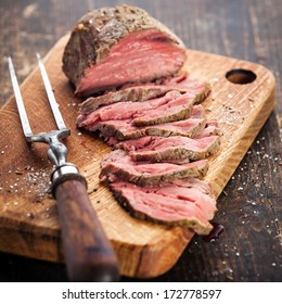 Roast Beef On Cutting Board And Meat Fork