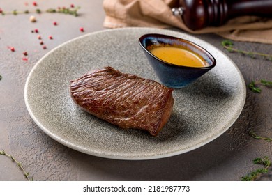 Roast Beef Steak With Honey Mustard Sauce On Plate On Brown Table