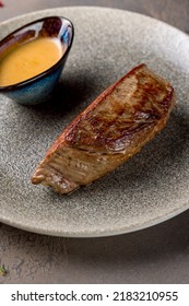 Roast Beef Steak With Honey Mustard Sauce On Plate On Brown Table