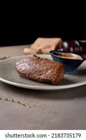 Roast Beef Steak With Honey Mustard Sauce On Plate On Brown Table