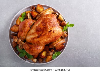 Roast chicken with roast potatoes and mushrooms on plate