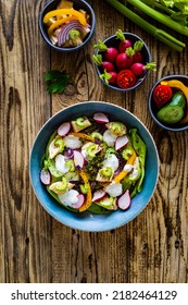 Roast Chicken Salad With Radish, Cucumber, Yellow Pepper And Leafy Greens Vegetables On Wooden Table 