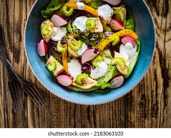 Roast Chicken Salad With Radish, Cucumber, Yellow Pepper And Leafy Greens Vegetables On Wooden Table 