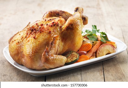 Roast Chicken And Various Vegetables On A White Plate