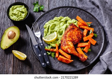 Roast Chicken With Wasacaca Sauce Of Avocado, Green Pepper And Herbs And Sweet Potato Chips On Black Plate On Wooden Table, Horizontal View From Above