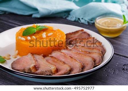 Roast duck breast and pumpkin mash, served with mint and pine nuts. Slices of duck with sweet butter squash, mustard and honey sauce. View From Above, Top Studio Shot