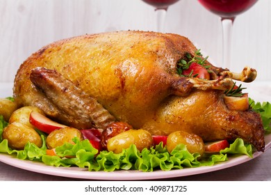 Roast Duck With Potato, Apples, Salad, Thyme And Rosemary. Two Glasses Of Red Wine