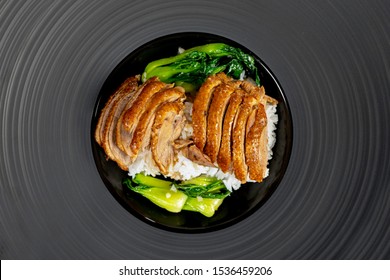 Roast Duck with rice and vegetable in black plate