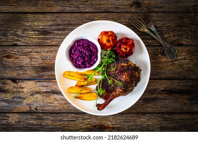 Roast Duck Thigh With, Baked Potatoes, Fruits And And Red Cabbage On Wooden Table 