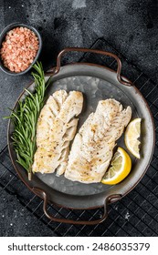 Roast Fillets of codfish, cooked cod fish meat. Black background. Top view.