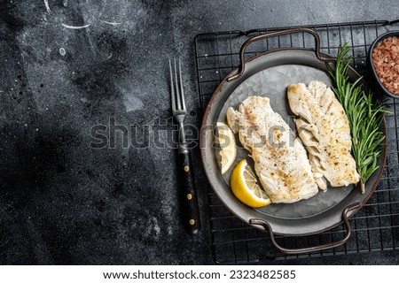 Roast Fillets of codfish, cooked cod fish meat. Black background. Top view. Copy space