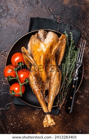 Roast guinea fowl with herbs and spices, cooked game bird. Dark background. Top view.