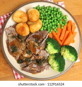 Roast lamb dinner with vefetables gravy and mint sauce.