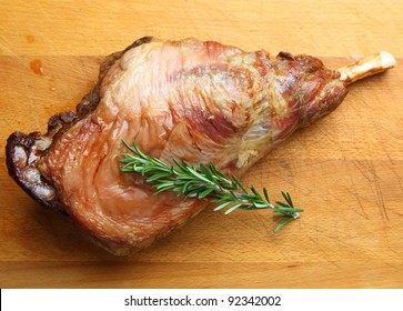 Roast Leg Of Lamb On Wooden Carving Board