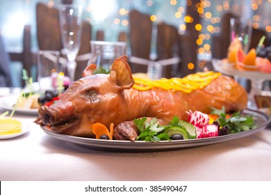 Roast pig. Roasted piglet with vegetables on platter - Shutterstock ID 385490467