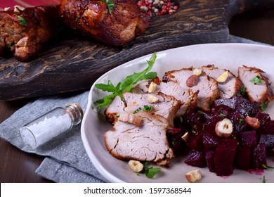 Roast pork meat cut into slices served with stewed beet roots on the white plate - Powered by Shutterstock