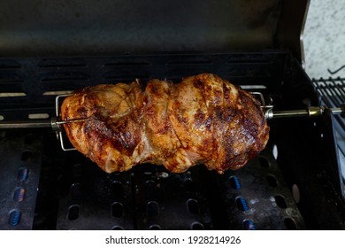 Roast pork on skewers on the gas grill