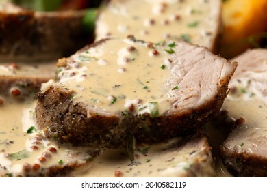 Roast Pork Tenderloin in mustard gravy with vegetables and potato wedges. - Shutterstock ID 2040582119