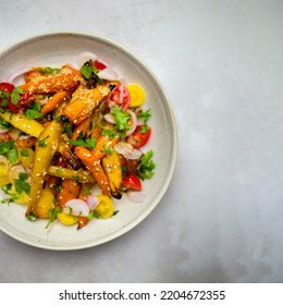 Roast Vegetable Salad With Carrots Tomatoes And Sesame Seeds. White Plate On A Grey Background. A Plant-based Healthy Vegan Meal. Beautiful Food Photography.