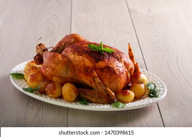 Roast whole chicken with potatoes on plate