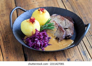 roast wild boar with dumplings - Shutterstock ID 2211427081