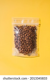 Roasted arabica coffee beans in blank transparent plastic bag with zipper on yellow background. Specialty and alternative sample coffee trendy concept. Space for text, mock up, top view, flat lay - Shutterstock ID 2013345833