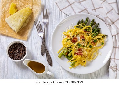 Roasted Asparagus Spears With Spaghetti Sprinkled With Shredded Cheese, Fried Bacon Pieces And Parsley On White Plate On White Textured Wood Table, Flat Lay