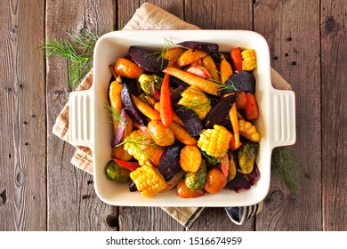 Roasted Autumn Vegetables In A Baking Dish, Top View Over A Rustic Wood Background